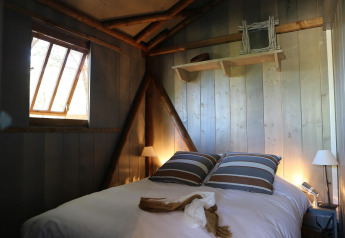 Cozy bedroom in a wooden cabin at Hut Lodge hout Comfort, Flower Camping Le Bel Air, France.