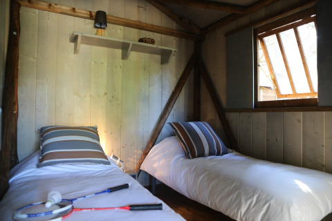Two single beds in a cozy wooden room at Hut Lodge hout Comfort, Flower Camping Le Bel Air, France.