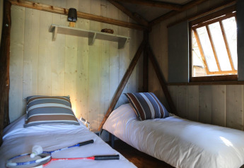 Two single beds in a cozy wooden room at Hut Lodge hout Comfort, Flower Camping Le Bel Air, France.