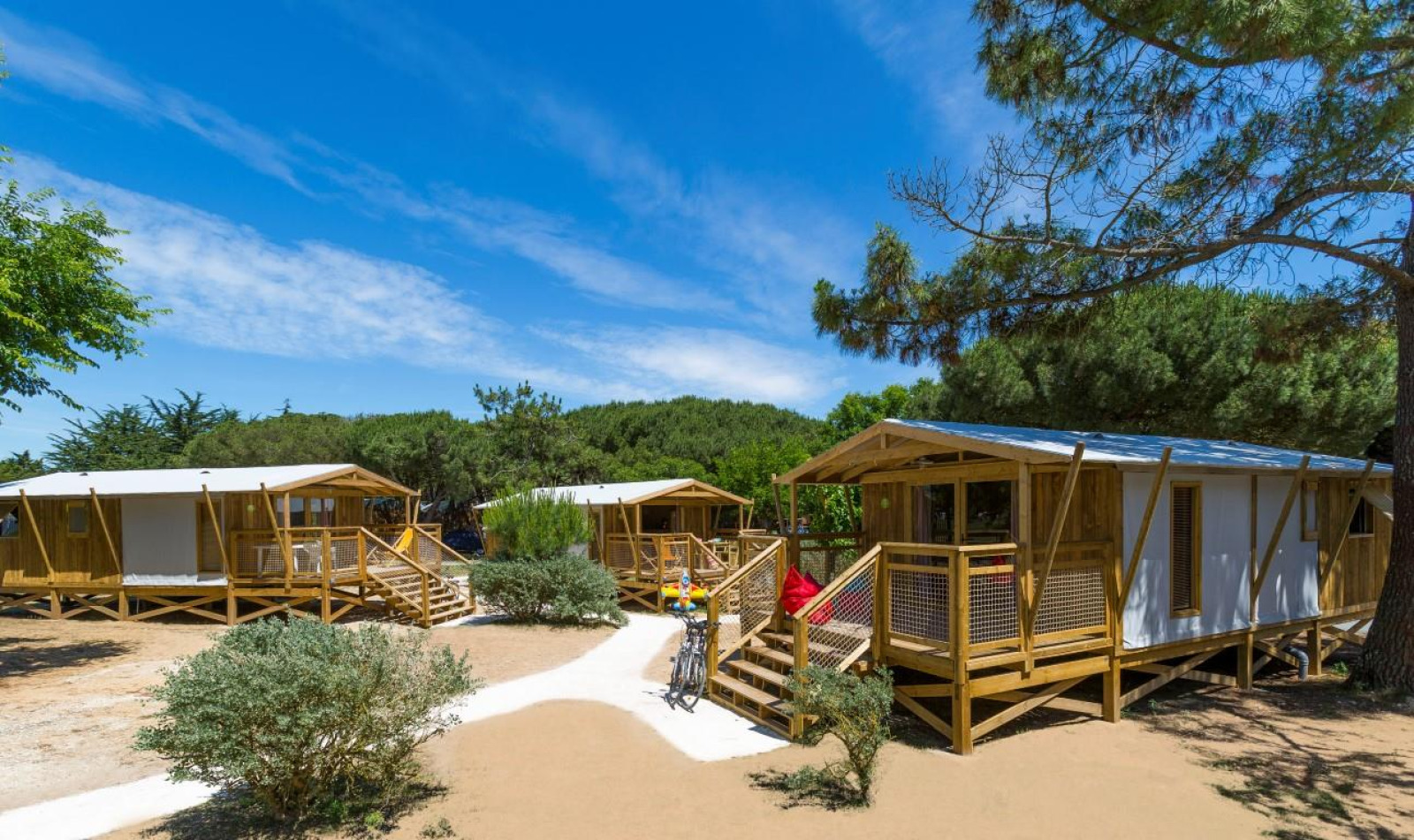 Safari tenten Sweetflower Premium bij Flower Camping Le Bel Air in Frankrijk, omringd door natuur en blauwe lucht.