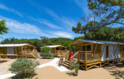 Safari tenten Sweetflower Premium bij Flower Camping Le Bel Air in Frankrijk, omringd door natuur en blauwe lucht.