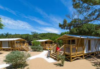 Safari tenten Sweetflower Premium bij Flower Camping Le Bel Air in Frankrijk, omringd door natuur en blauwe lucht.