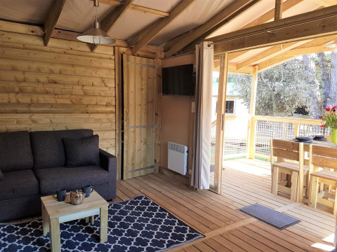 Interieurfoto van het Cosyflower Premium chalet met zithoek en eettafel bij Flower Camping Le Bel Air in Frankrijk.