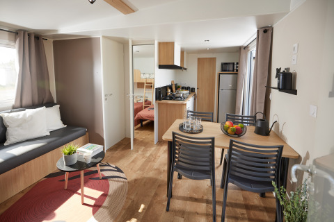 Salón y comedor contemporáneo en la cabaña Homeflower Premium con cocina, sofá y luz natural.