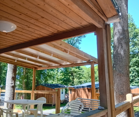 Terrasse en bois avec chaises en plastique de Standaard Houten Stacaravan au Flower Camping La Chênaie, France.