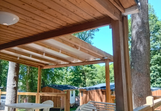 Terrasse en bois avec chaises en plastique de Standaard Houten Stacaravan au Flower Camping La Chênaie, France.