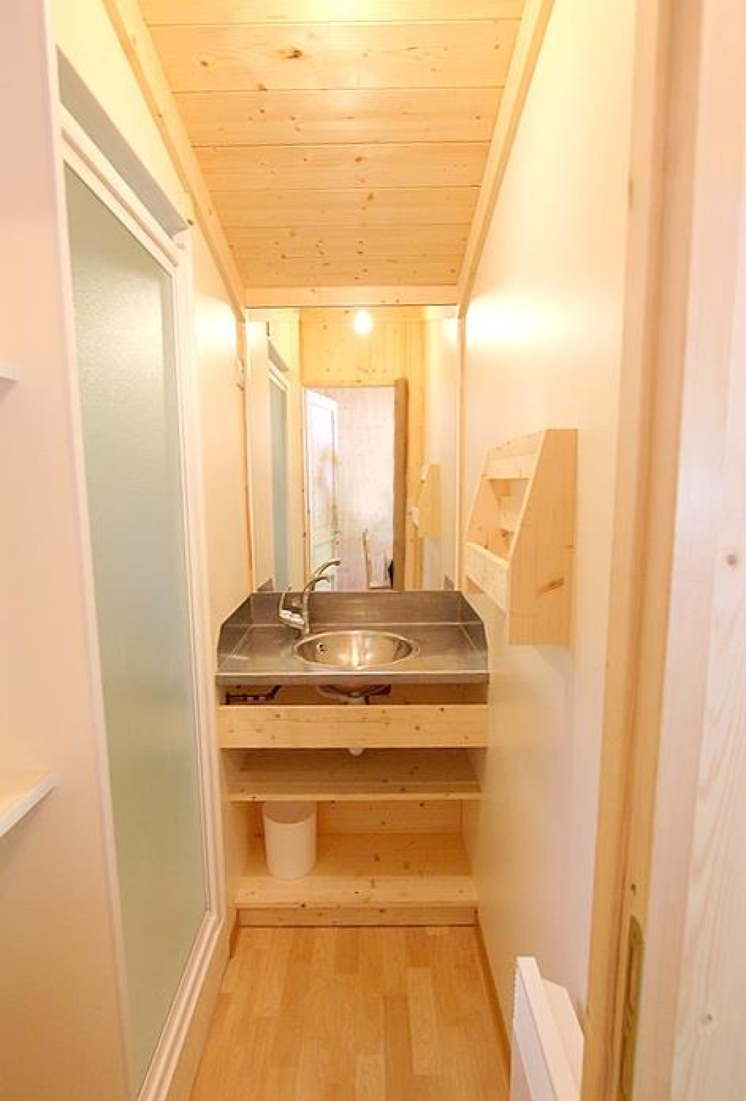 Smalle badkamer met houten plafond en moderne wasbak in Chalet Bois Comfort bij Flower Camping La Chênaie.