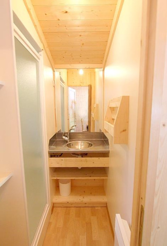 Salle de bain étroite avec plafond en bois et lavabo moderne au Chalet Bois Comfort à Flower Camping La Chênaie.