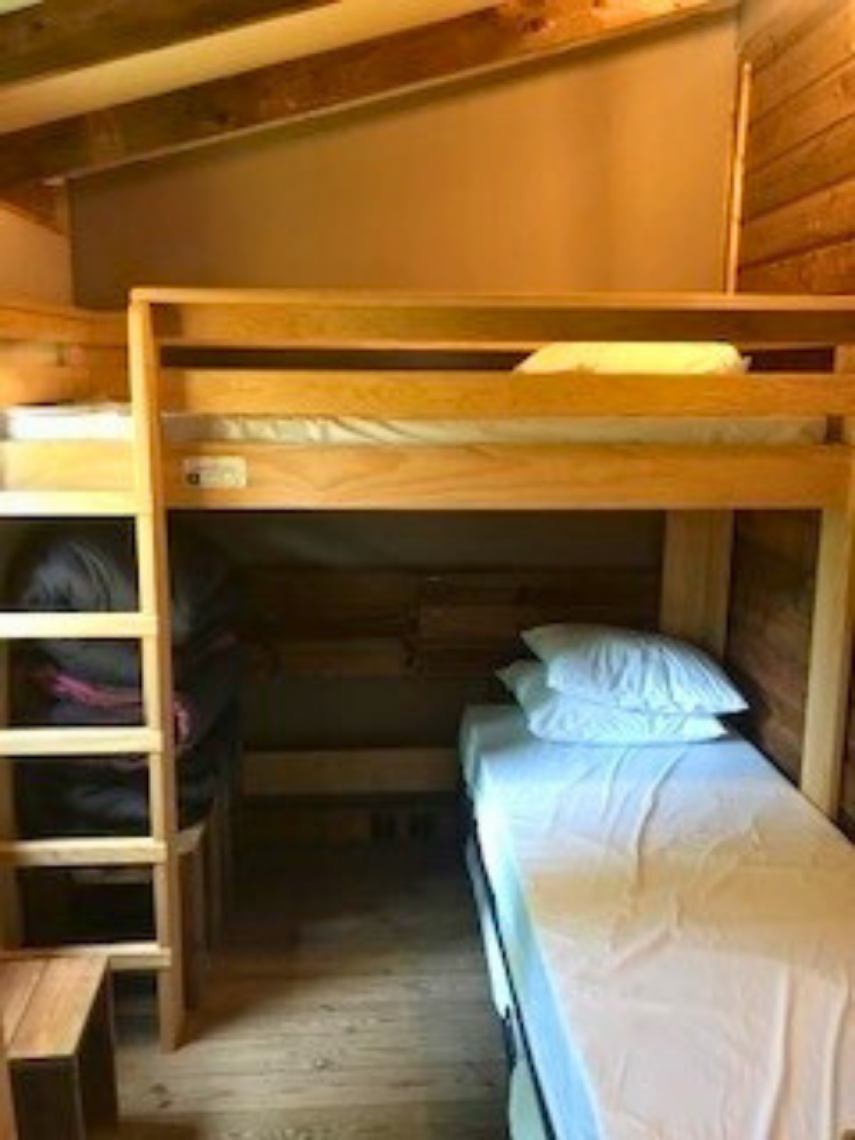 Houten stapelbed in een knusse lodgekamer met schuin plafond bij Flower Camping La Chênaie in Frankrijk.