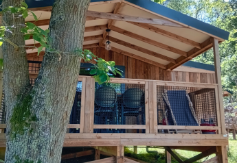 Vista del Lodge VIP Premium en el Flower Camping La Chênaie en Francia, rodeado de árboles y naturaleza.