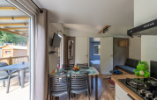 Modernes Glamping-Unterkunft mit Essbereich, Küche, Schlafzimmer und Terrasse mit Naturblick.