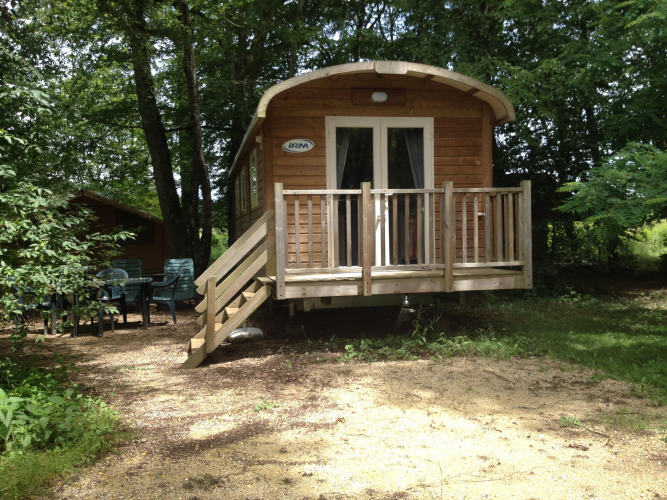 Roulotte Standard al Flower Camping La Sagne in Francia, immersa nel verde con terrazza e area esterna.