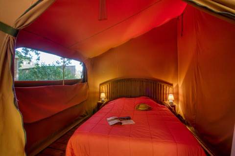 Interiør af Freeflower Confort safaritelten på Flower Camping La Sagne i Frankrig, med dobbeltseng.