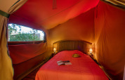 Interieur van de Freeflower Confort safaritent op Flower Camping La Sagne in Frankrijk met tweepersoonsbed.
