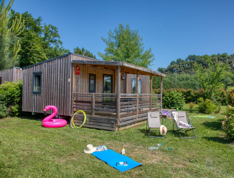 Außenansicht der Stacaravan Campbell Premium Lodge mit Terrasse, grünem Garten und Sommeraccessoires.