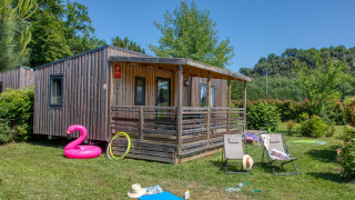 Außenansicht der Stacaravan Campbell Premium Lodge mit Terrasse, grünem Garten und Sommeraccessoires.