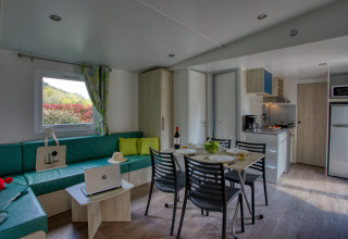 Vista interior de una sala y cocina moderna en Stacaravan Campbell Premium en Flower Camping La Sagne, Francia.