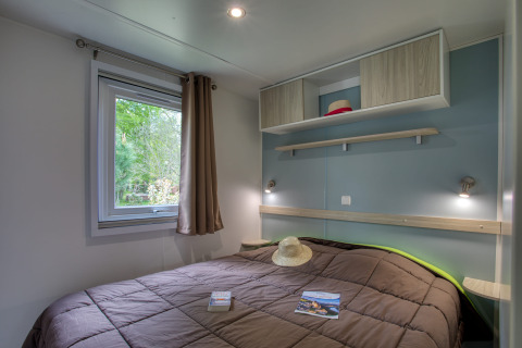 Dormitorio de la Stacaravan Campbell Premium en Flower Camping La Sagne, Francia, con decoración moderna.