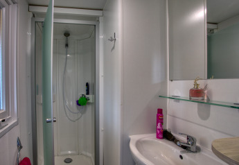 Modernes Badezimmer mit Duschkabine, Waschbecken und Spiegel im Stacaravan Campbell Premium, La Sagne.