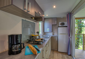 Cuisine de mobil-home moderne avec cafetière, pain et cuisinière au Stacaravan Cayuga Confort en France.