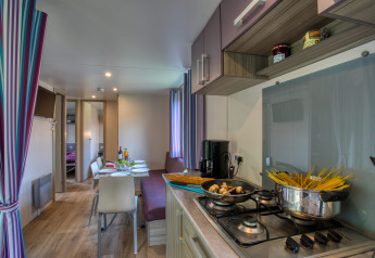 Cuisine et coin repas modernes dans le mobil-home Stacaravan Cayuga Confort au Flower Camping La Sagne, France.