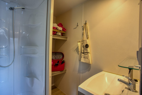 Badkamer in Stacaravan Cayuga Confort, Flower Camping La Sagne, Frankrijk, met zichtbare douche en wastafel.