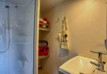 Badkamer in Stacaravan Cayuga Confort, Flower Camping La Sagne, Frankrijk, met zichtbare douche en wastafel.