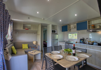 Zona giorno e cucina moderna nella Stacaravan Arlequin Premium al Flower Camping La Sagne in Francia.