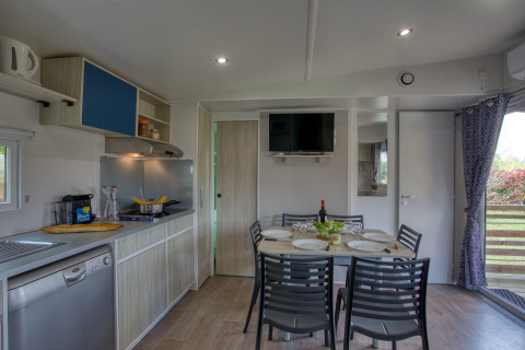 Moderne Küche und Essbereich im Stacaravan Arlequin Premium auf dem Flower Camping La Sagne in Frankreich.