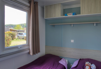 Gemütliches Zimmer mit zwei Einzelbetten in der Stacaravan Arlequin Premium bei Flower Camping La Sagne.