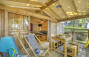 Sonnige Holzterrasse mit Liegestühlen und gedecktem Tisch an der Hut Lodge Cosyflower PREMIUM in Le Conleau.