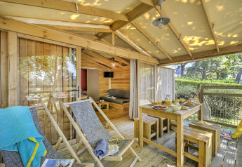 Sonnige Holzterrasse mit Liegestühlen und gedecktem Tisch an der Hut Lodge Cosyflower PREMIUM in Le Conleau.