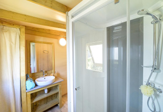 Bathroom with shower and wooden vanity at Hut lodge Cosyflower PREMIUM, Flower Camping Le Conleau, France.