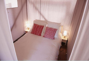 Schlafbereich in einem Safarizelt bei Hut Lodge Standaard, Flower Camping Le Bois d'Amour, Frankreich.