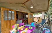Safari-telt Hut Lodge Comfort med farverig terrasse og morgenmad på Flower Camping Le Bois d'Amour i Frankrig.
