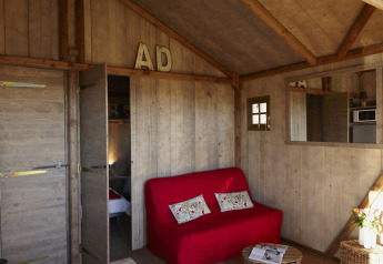 Intérieur d'une tente safari Hut Lodge Comfort au Flower Camping Le Bois d'Amour en France, décor rustique.