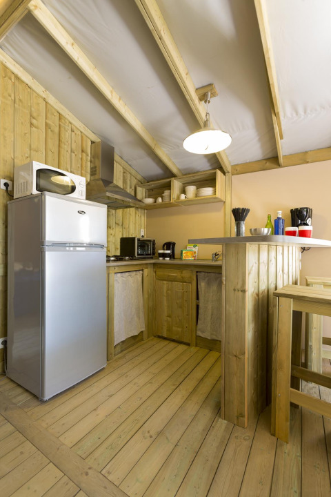 Cucina in legno con elettrodomestici moderni in una tenda safari Hut Sweetflower Premium, Flower Camping Le Bois d'Amour, Francia.