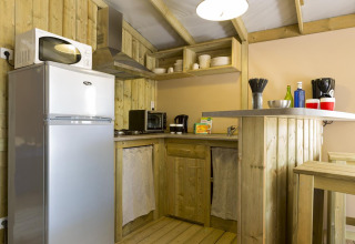 Cucina in legno con elettrodomestici moderni in una tenda safari Hut Sweetflower Premium, Flower Camping Le Bois d'Amour, Francia.