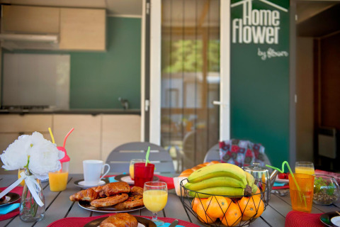 Breakfast table with pastries and fruit at Homeflower Premium lodge, Flower Camping Le Bois d'Amour in France.