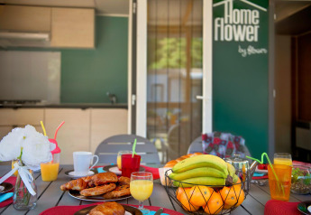 Tavola della colazione con frutta e dolci presso Homeflower Premium, Flower Camping Le Bois d'Amour, Francia.