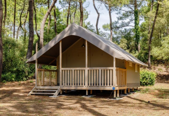 Safari tent named Tent Lodge Confort set in a peaceful forest environment with trees all around.