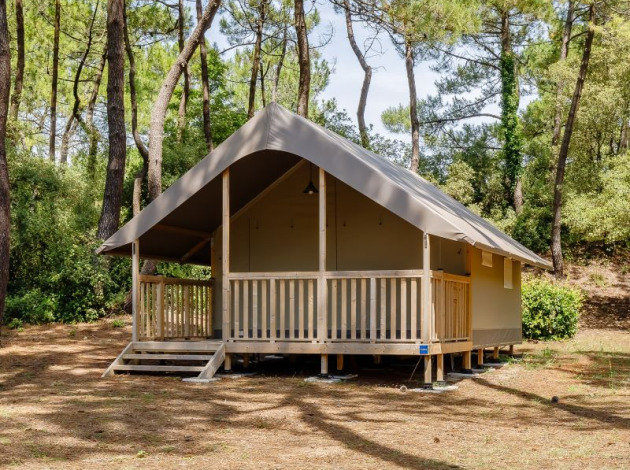 Safaritent genaamd Tent Lodge Confort in een rustige bosrijke omgeving met bomen rondom.