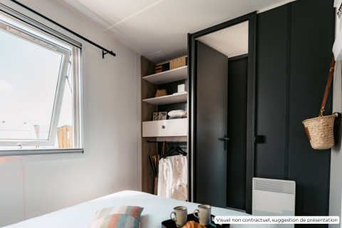 Dormitorio moderno con armario negro, ventana abierta y decoración minimalista en Homeflower Premium en Francia.