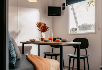 Lyst og moderne interiør i Homeflower Premium 1-værelses lodge ved Flower Camping Les Dunes i Frankrig.