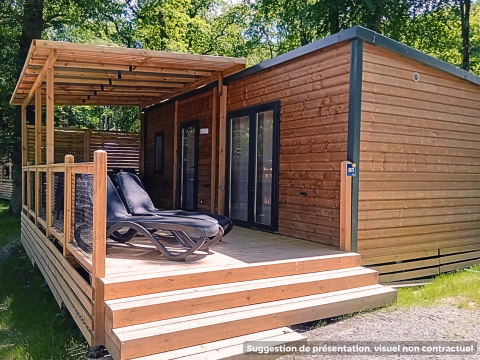 Houten lodge met overdekt terras en ligstoelen in een groene omgeving, Homeflower Premium lodge.