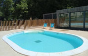 Udendørs swimmingpool med to blå liggestole ved Camping Seasonova Vittel i Grand Est, Frankrig, omgivet af træer.