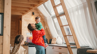 Famiglia trascorre un momento felice nella baita di legno al Big Oak Tent nell’Holiday Park Sallandshoeve.