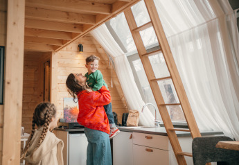 Familie genießt Zeit in einer Holzhütte im Big Oak Tent im Holiday Park Sallandshoeve, Niederlande.