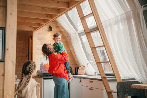 Familie genießt Zeit in einer Holzhütte im Big Oak Tent im Holiday Park Sallandshoeve, Niederlande.