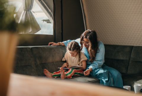 Mère et fille lisent ensemble dans la tente Big Oak au Holiday Park Sallandshoeve, Pays-Bas.